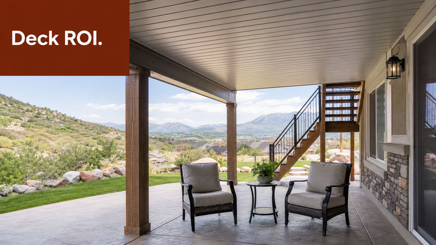 A covered patio area underneath a wooden deck overlooking a scenic mountain landscape on a sunny day.